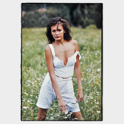 Young woman with white dress in meadow with flowers