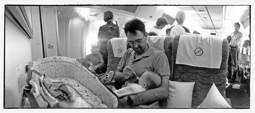 Man feeding his young son during a plane travel